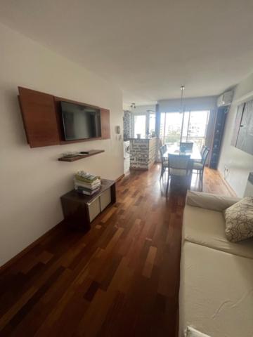 a living room with a couch and a tv and a table at MANU. Moderno 2 dormitorios grande y luminoso. 2 baños. Cochera. Amenities in Rosario