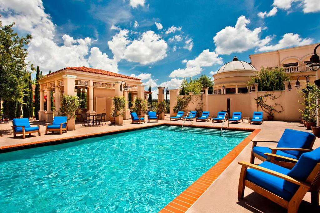 a pool with blue lounge chairs and a building at The Westin Huntsville in Huntsville