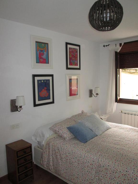 a bedroom with a bed and some pictures on the wall at Al Rincon de Emi in Carreña de Cabrales 