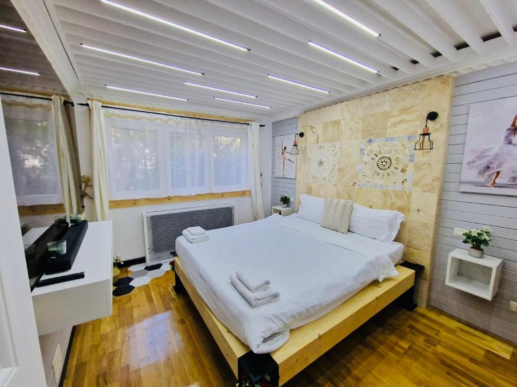 Schlafzimmer mit einem Bett, einem Schreibtisch und einem TV in der Unterkunft Arthitekt I Afi Cotroceni in Bukarest