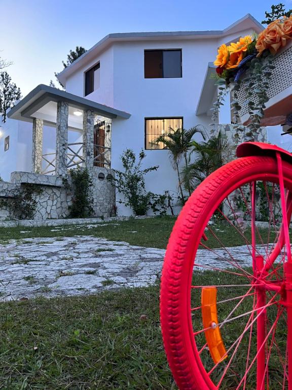 Villa Colinas Del Cielo في San Cristóbal: منزل أمامه دراجة حمراء