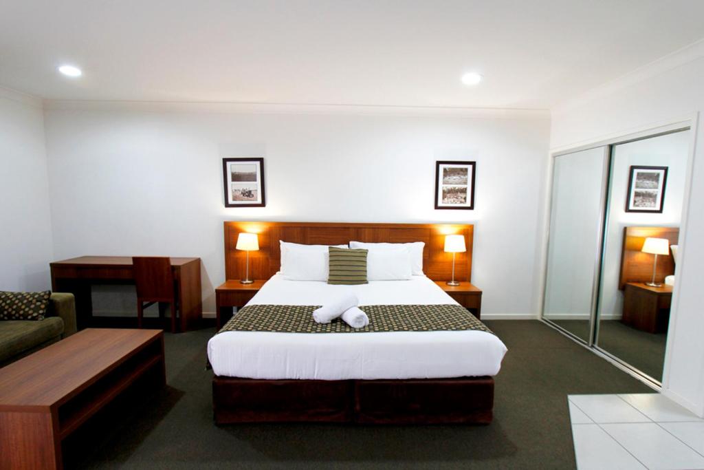 una camera d'albergo con letto e scrivania di Chinchilla Downtown Motor Inn a Chinchilla