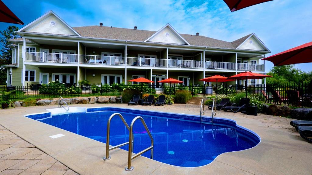 a resort with a swimming pool in front of a building at Condo 202 Le Champlain vue sur la montagne, ski, vélo, piscine ! in Bromont