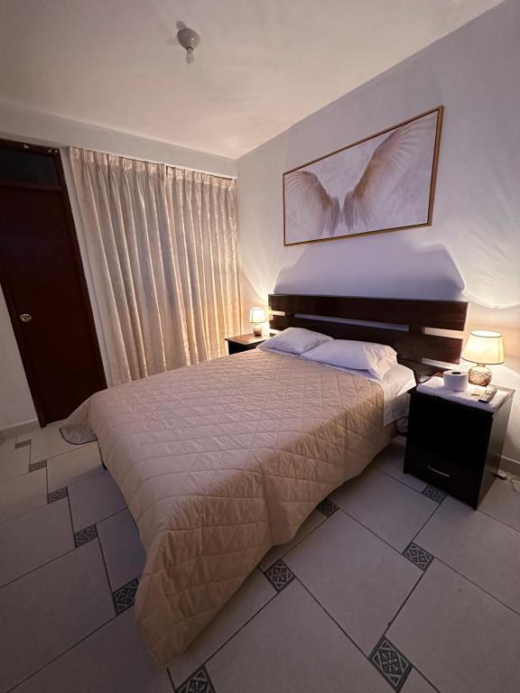 1 dormitorio con 1 cama, 2 lámparas y ventana en LUX - HOTEL BOUTIQUE, en Andahuaylas