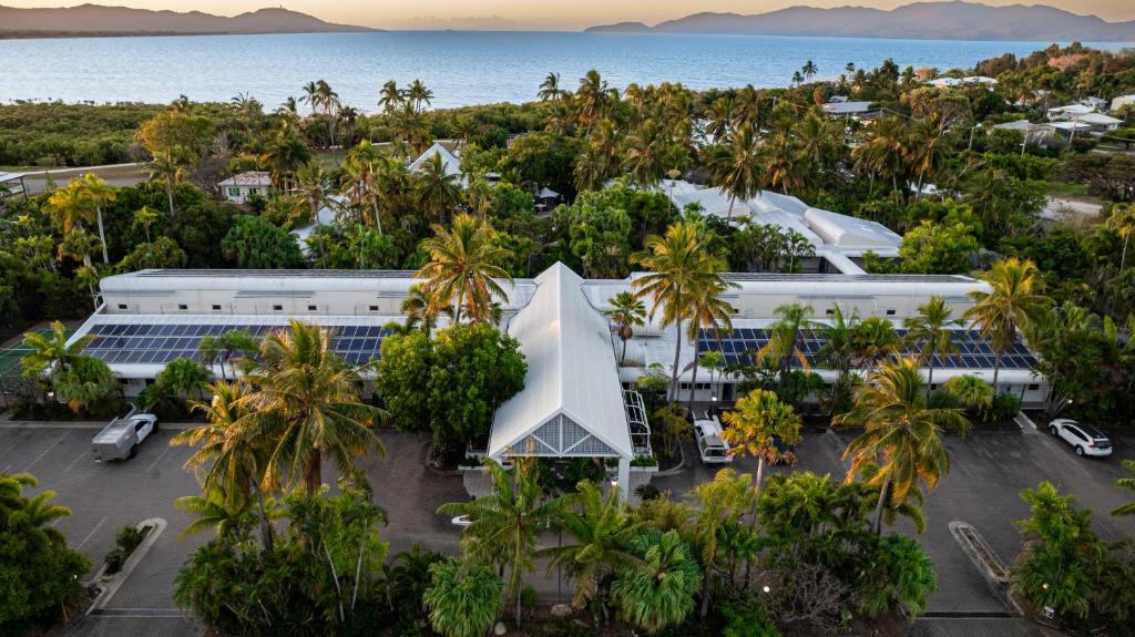 uma vista aérea de um edifício com palmeiras e do oceano em Seagulls em Townsville