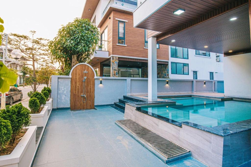 a swimming pool with a wooden door in a building at Sea Villa - FLC Sam Son in Sầm Sơn