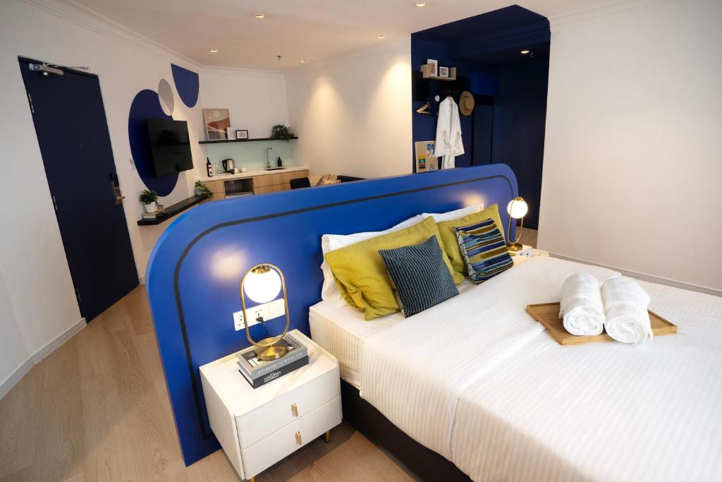 een groot bed met een blauw hoofdeinde in een kamer bij Ukiyo Hotel in Petaling Jaya