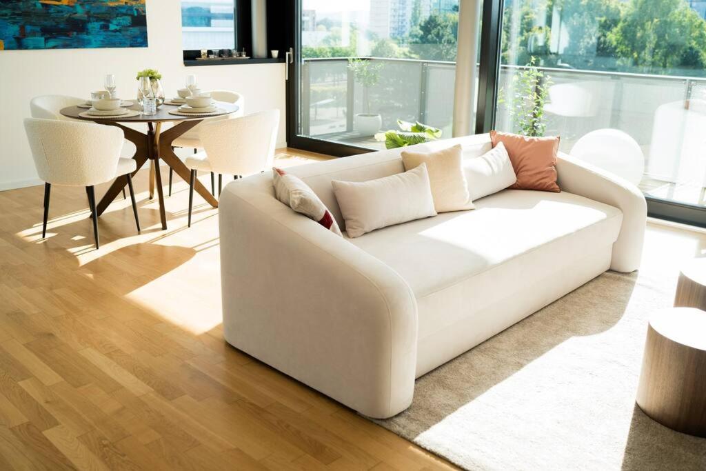 ein weißes Sofa im Wohnzimmer mit einem Tisch in der Unterkunft NEU! Zentral & Großzügig mit Panoramablick in Dresden