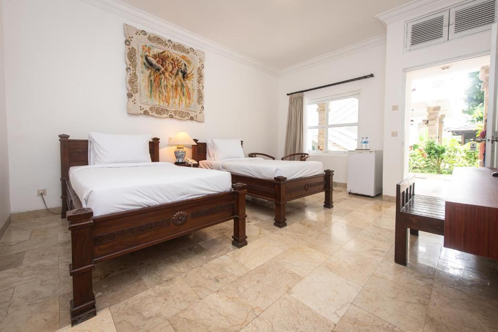 Postel nebo postele na pokoji v ubytování Sari Bunga Hotel Legian Kuta Bali