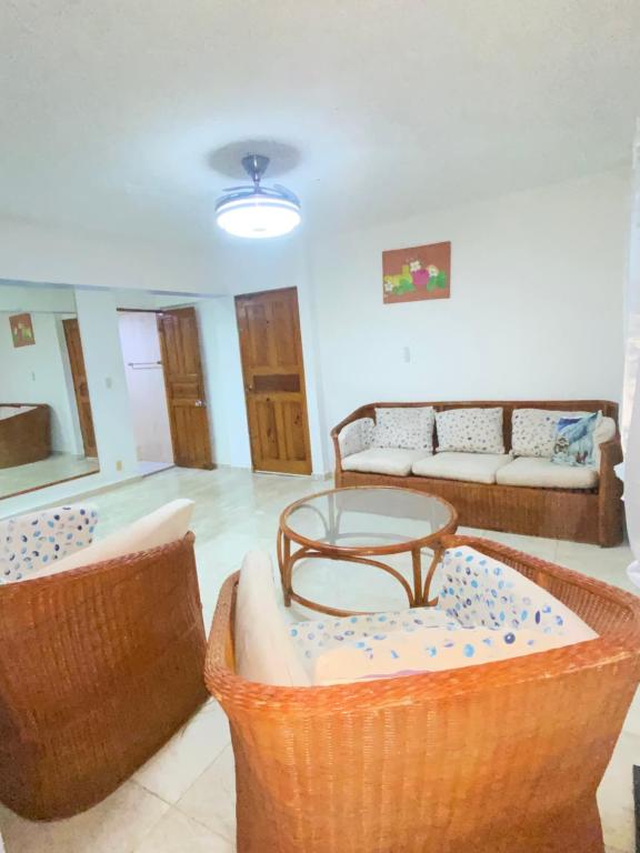a living room with two baskets and a table at Apartamento con vista al mar in San Felipe de Puerto Plata
