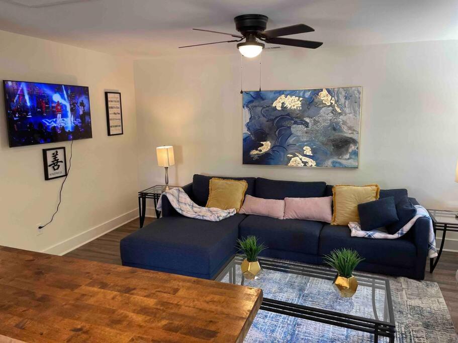 een woonkamer met een blauwe bank en een plafondventilator bij Charming 2Br, Fully Equipped kitchen, Smart TV in Greenville