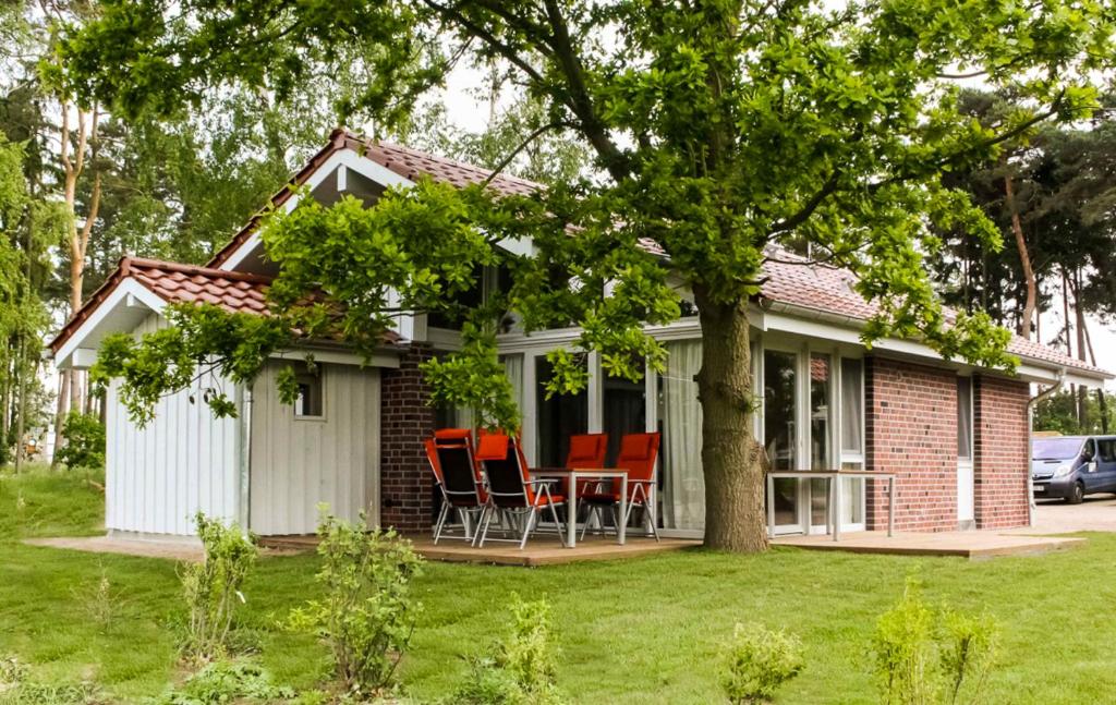 uma pequena casa com uma mesa e cadeiras no quintal em Ferienhaus Unter den Eichen em Röbel
