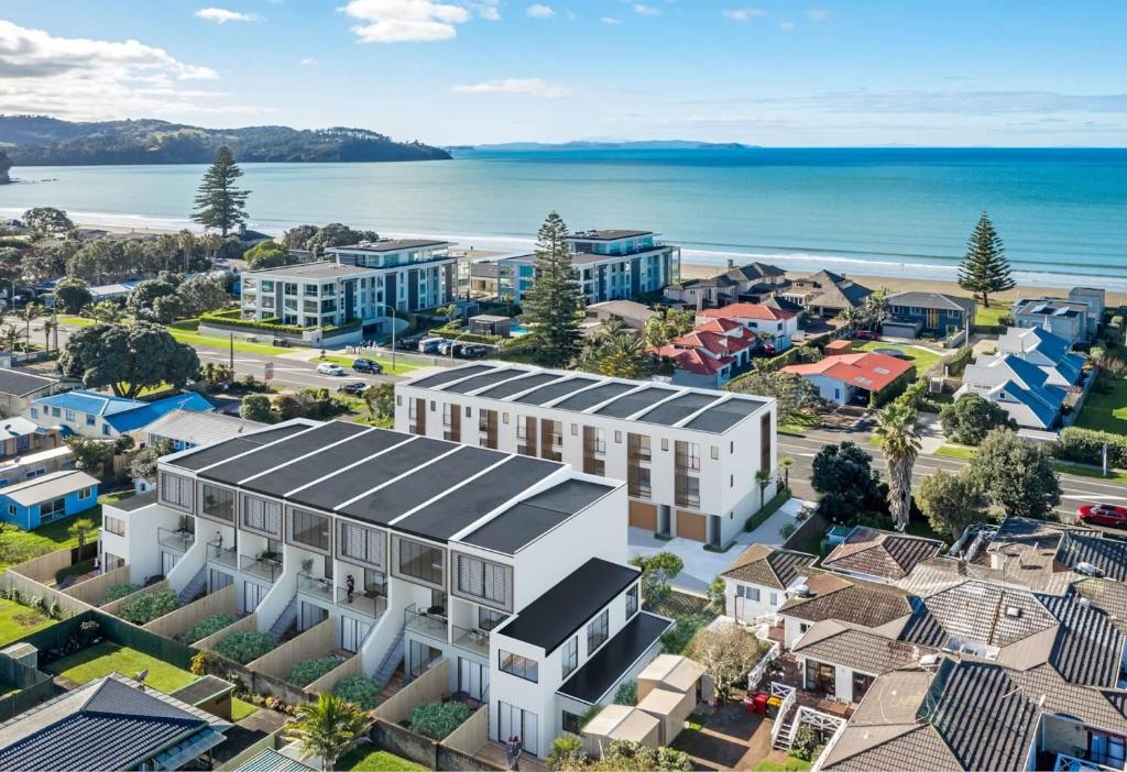 an aerial view of a city with buildings and the ocean at Sunny Beachside Home in Orewa