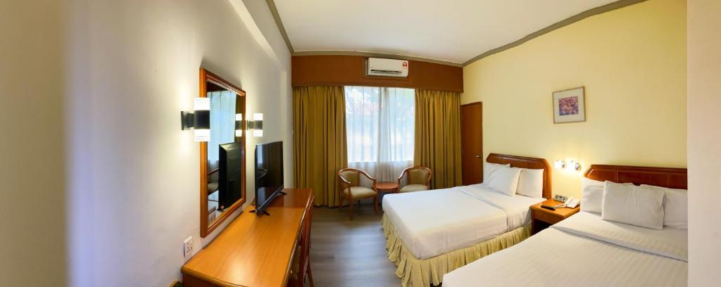 Postel nebo postele na pokoji v ubytování Hotel Sandakan
