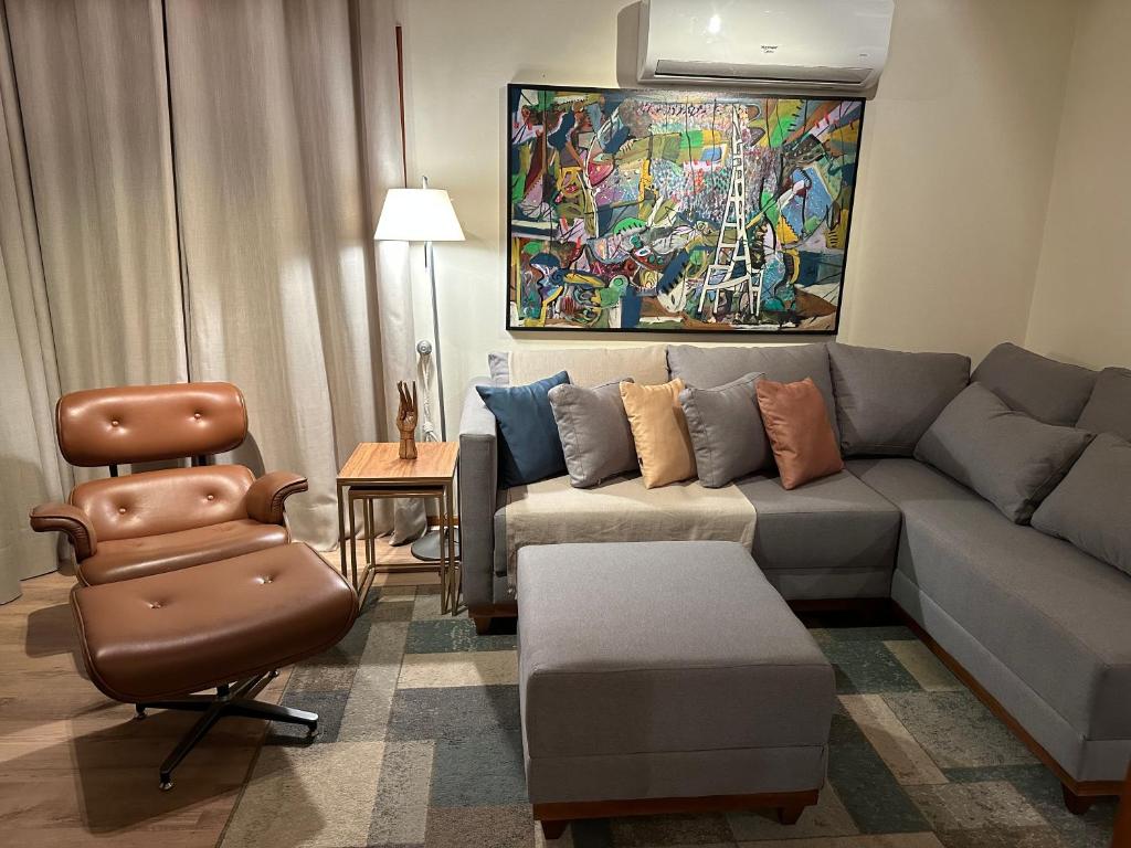 sala de estar con sofá y silla en Duplex 3 suites com Jacuzzi e Lareira Apto Sattva Plaza, en Gramado