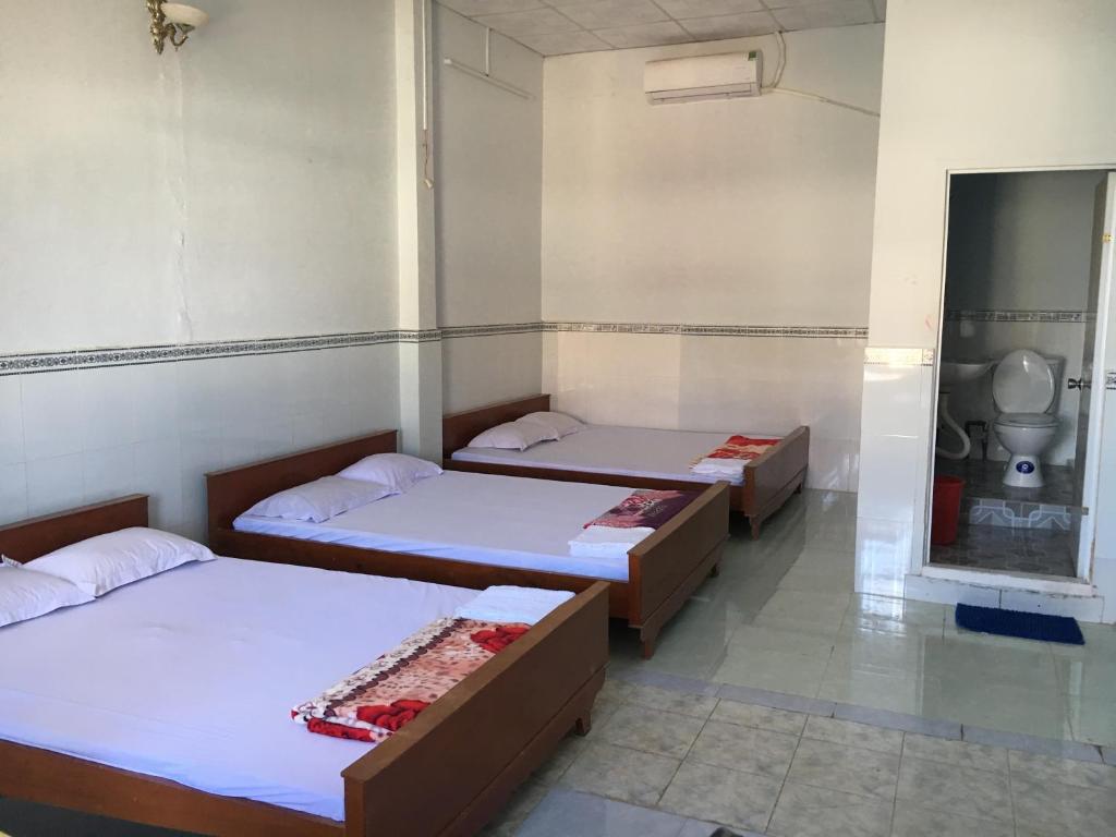 a group of three beds in a room at Khách sạn Thiên Phúc in Cà Mau
