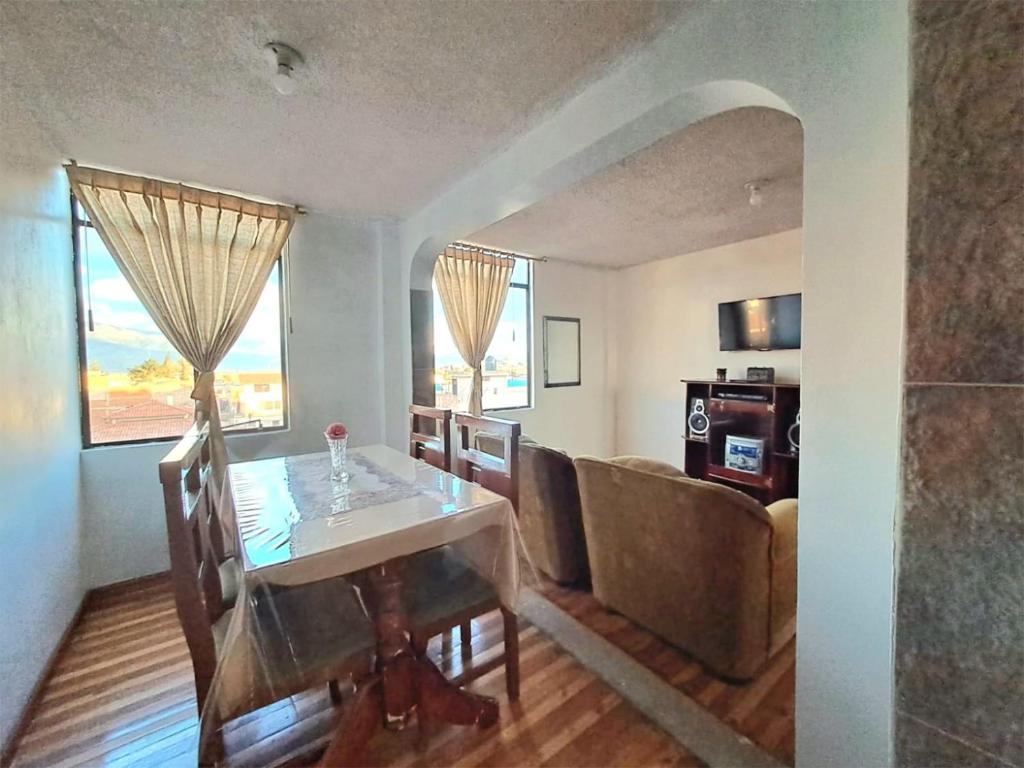 uma sala de jantar com uma mesa e um sofá em Alojamiento Comodo con Vista Espectacular em Riobamba