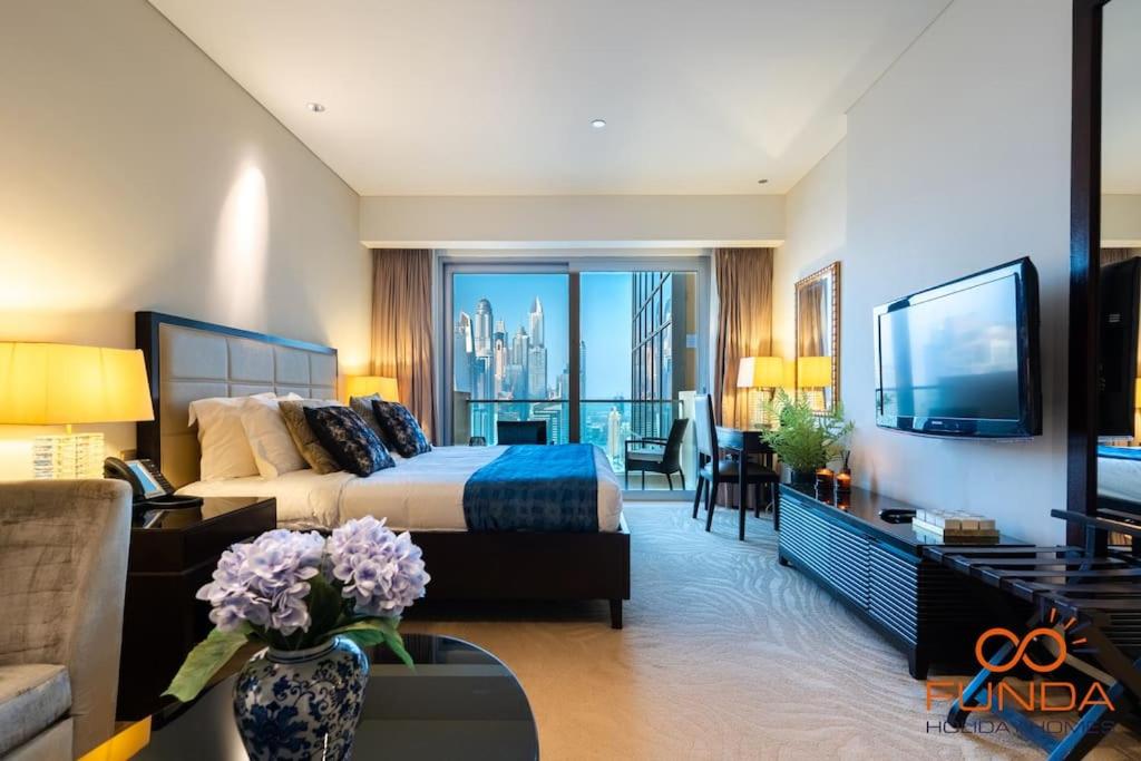 een grote hotelkamer met een bed en een woonkamer bij Luxe high floor Studio in address 36 in Dubai