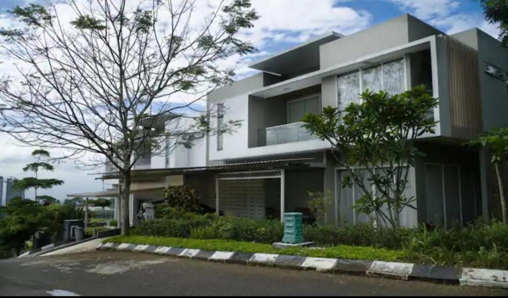 een groot wit huis met een boom ervoor bij Aryastri Villa in Bandung
