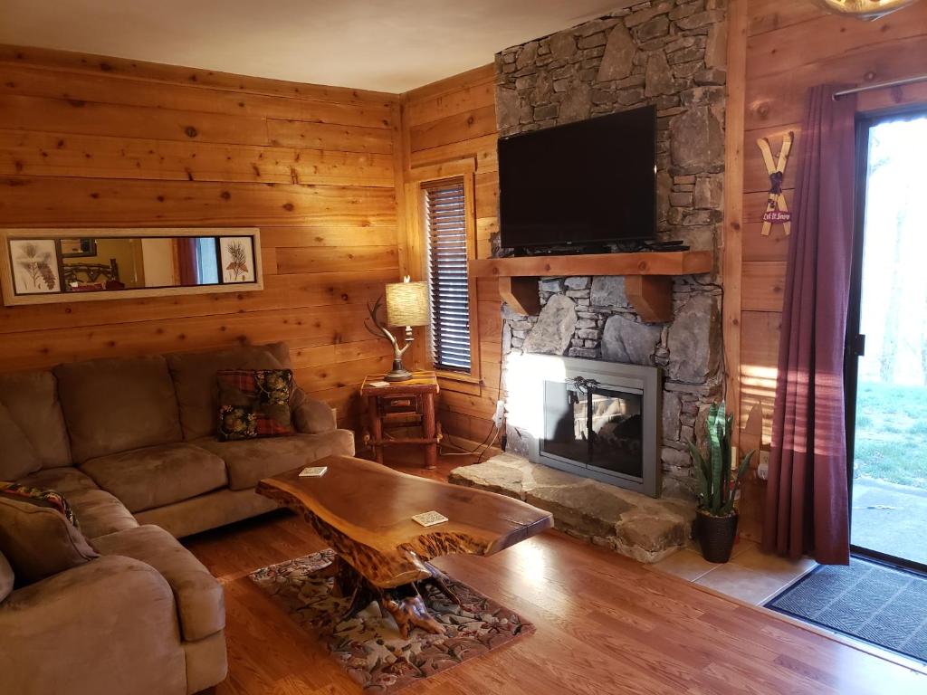 a living room with a couch and a fireplace at Adventure in the woods @ Seven Springs in Champion