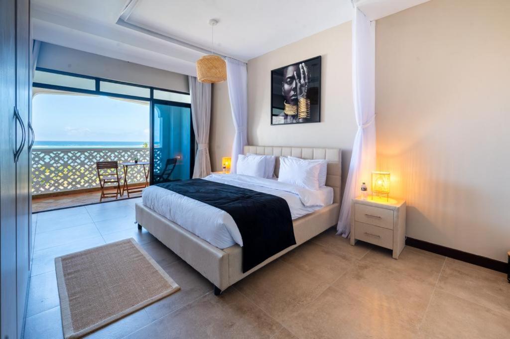 a bedroom with a bed with a view of the ocean at The Hayce residence beach Maisionette in Kilifi
