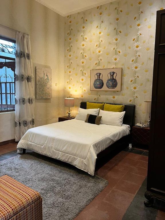 um quarto com uma cama grande e lençóis brancos em SOETJIPTO HOME STAY VILLA em Jakarta