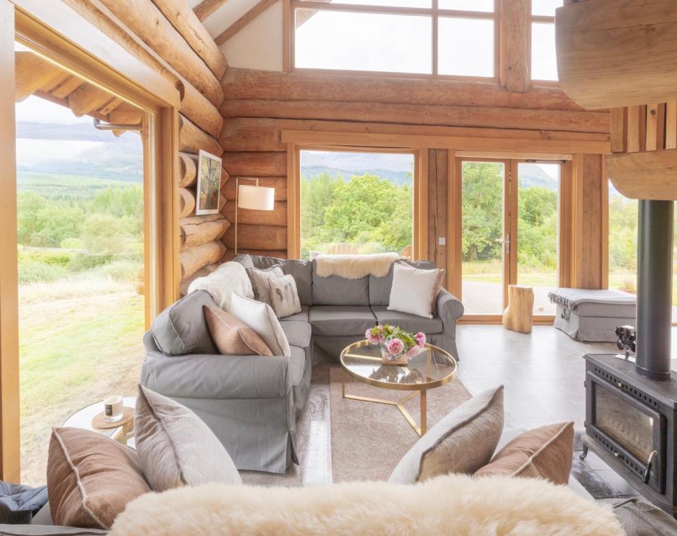 salon z kanapą i kominkiem w obiekcie Wild Nurture Eco Luxury Offgrid Log Cabin w mieście Fort William