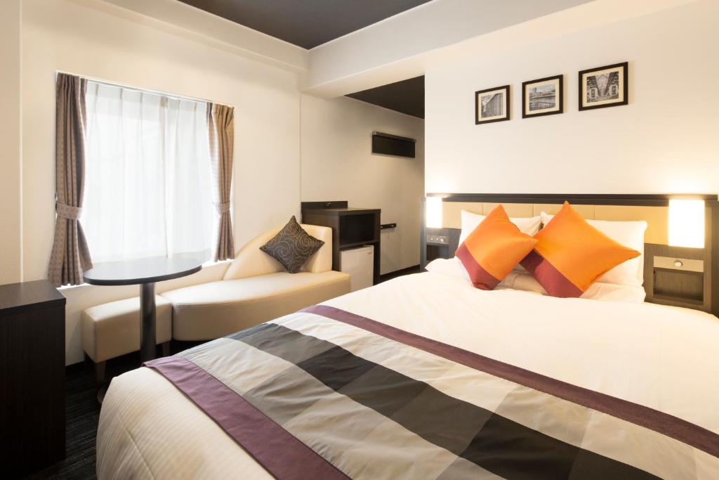 ein Hotelzimmer mit einem Bett und einem Stuhl in der Unterkunft HOTEL MYSTAYS Shinsaibashi in Osaka