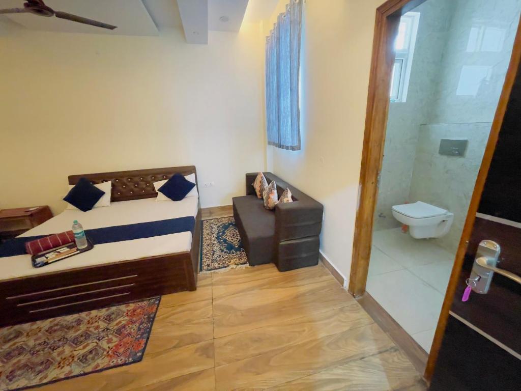 ATULYAM STAYS SUSHANT GOLF CITY LUCKNOW في لاكناو: غرفة نوم فيها سرير ودورة مياه
