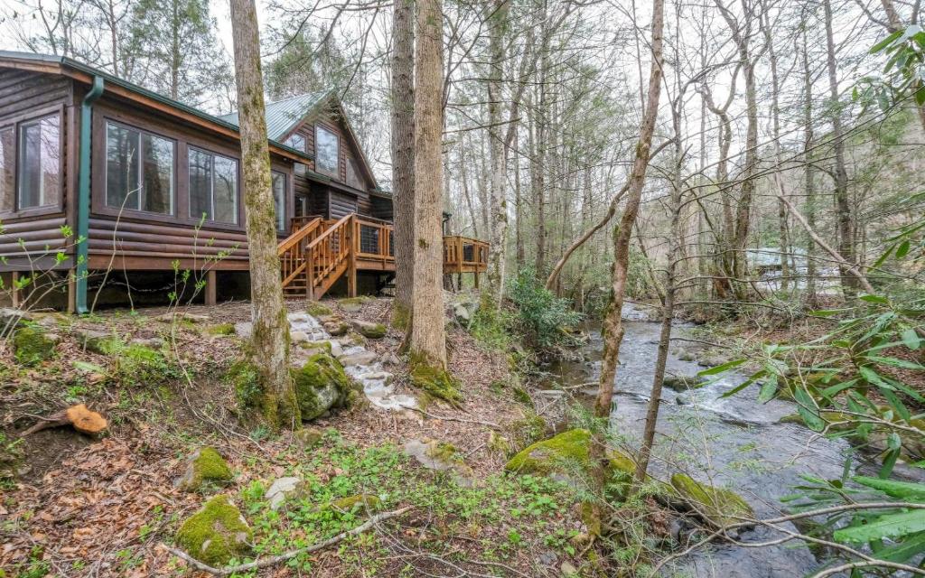a cabin in the woods with a wrap around deck at Shady Creek in Gatlinburg