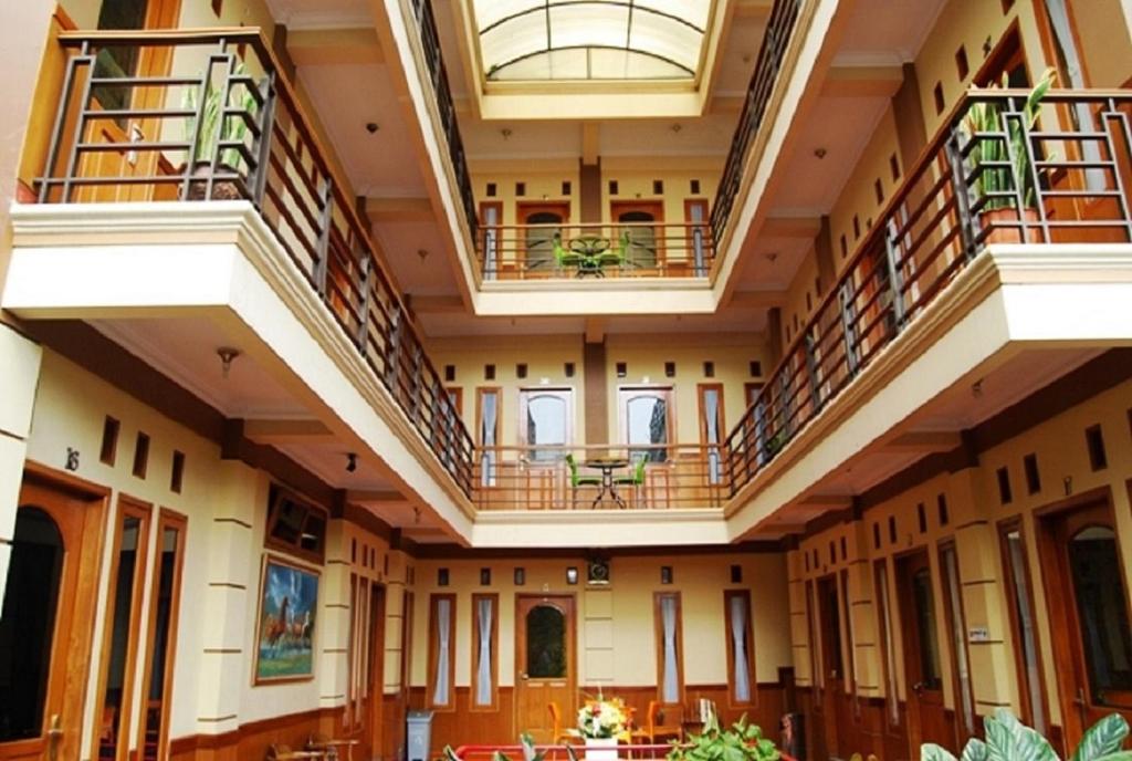 an image of a building with balconies and tables at Orange Home Syariah in Bandung