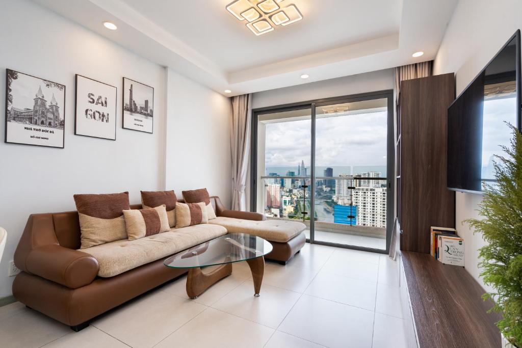 een woonkamer met een bank en een glazen tafel bij The Silver Gold View Apartment in Ho Chi Minh-stad
