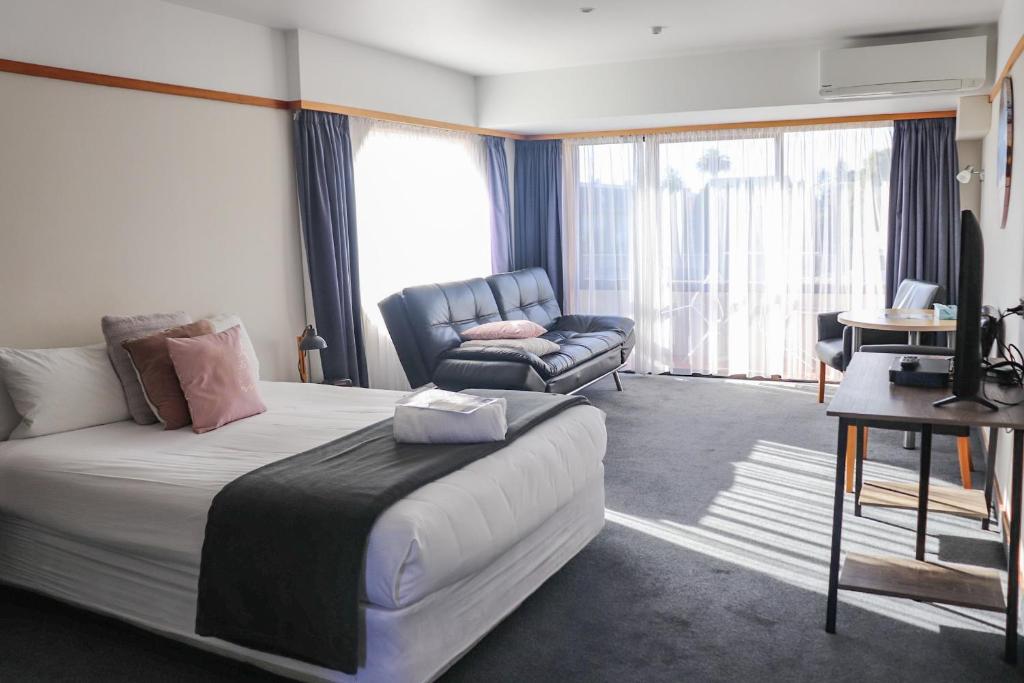 Habitación de hotel con cama y sofá en The Beachcomber Hotel, en Nelson