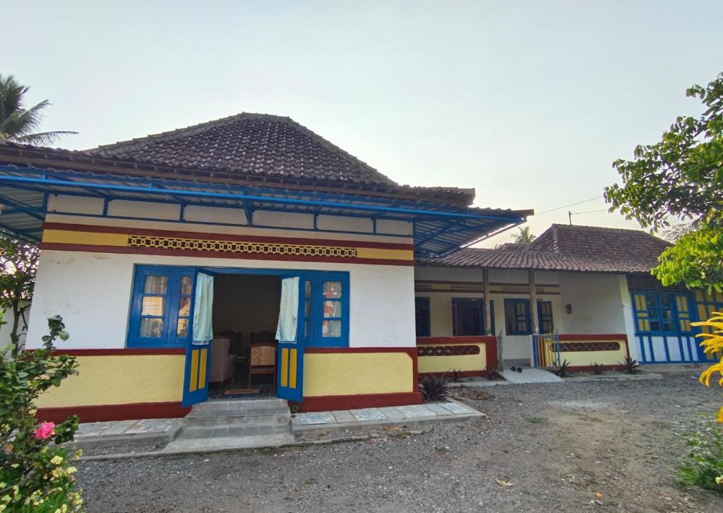 una pequeña casa azul y blanca en Sendangarum Village Guest House Jogja, 