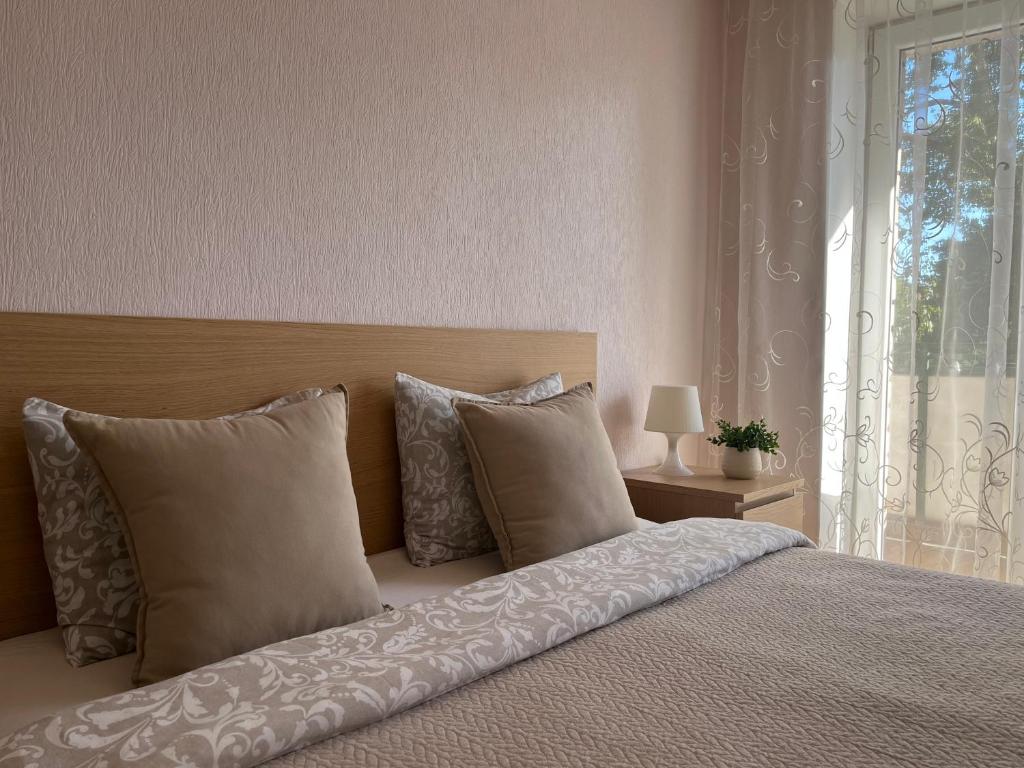 a bedroom with a bed with pillows and a window at Center two bedroom apartment in Daugavpils