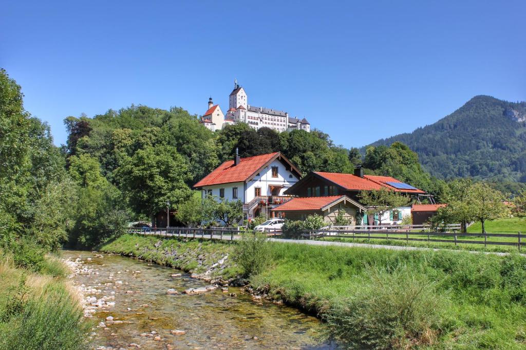 um edifício no topo de uma colina com um rio em Ferienwohnung Schlossblick em Aschau im Chiemgau