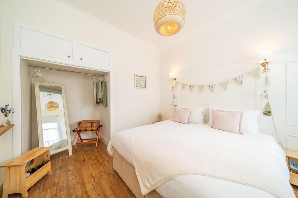 a bedroom with a large white bed and a table at Dreamy Town House Apartment in Dunkeld in Birnam