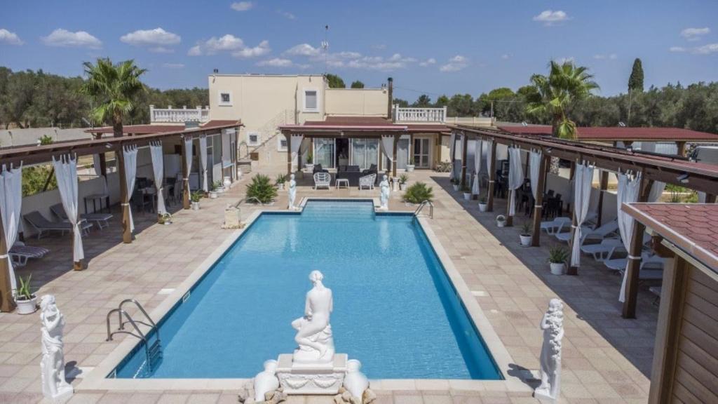 una piscina con una estatua en el medio de un edificio en Villa Jany- Adults only, en Oria