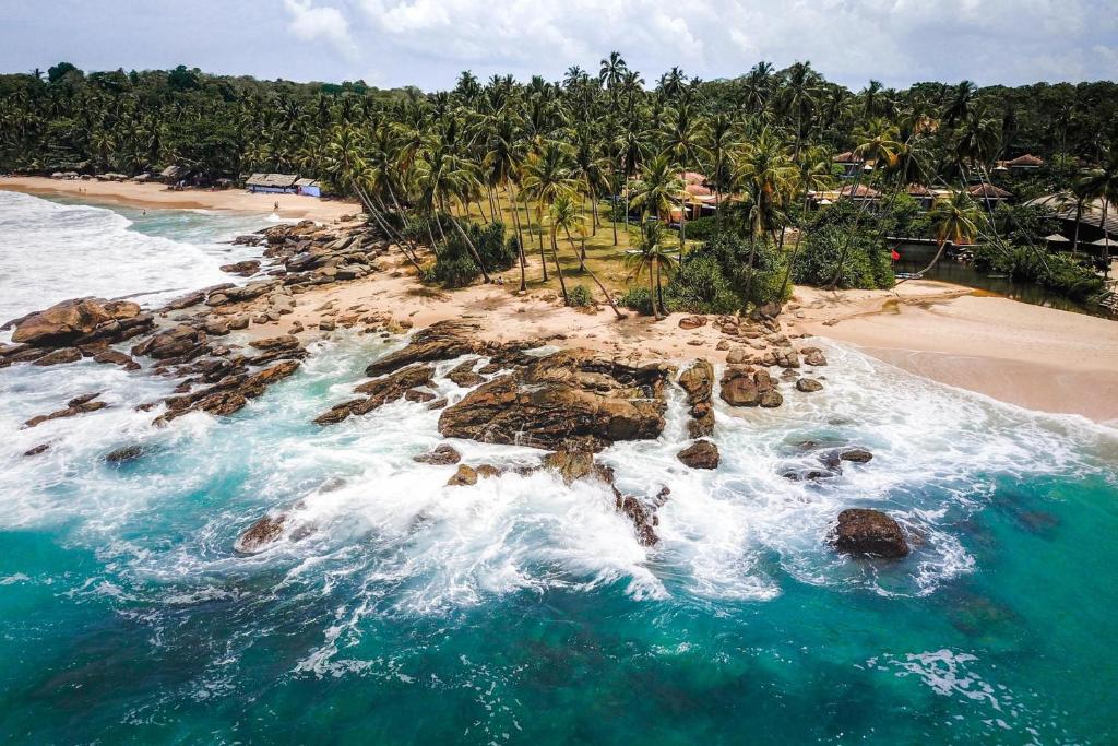 una vista aérea de una playa con rocas y el océano en D' Art VILLA RETREAT AND SPA, en Tangalle