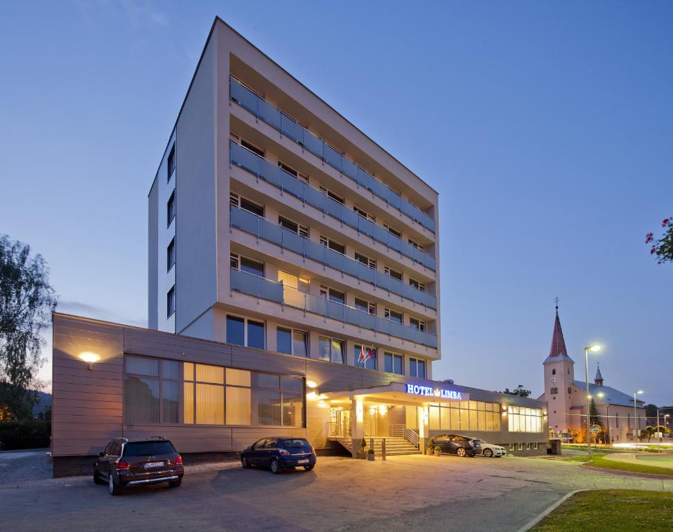 un edificio con coches estacionados frente a él en Hotel Limba CTT, en Tvrdošín