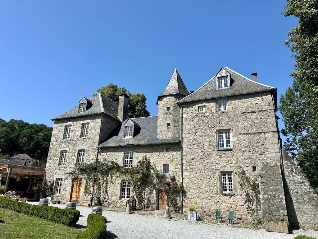 um grande edifício de pedra com uma torre em Château de la Borde à Ussel em Ussel