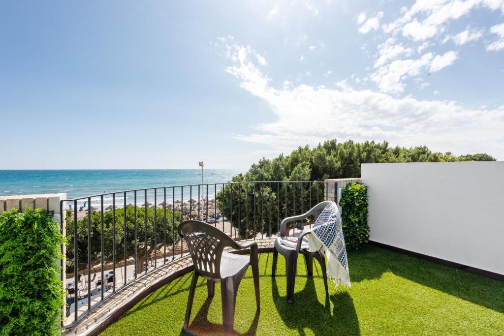 balcón con mesa, sillas y vistas al océano en Casa Mar de frente, en Málaga