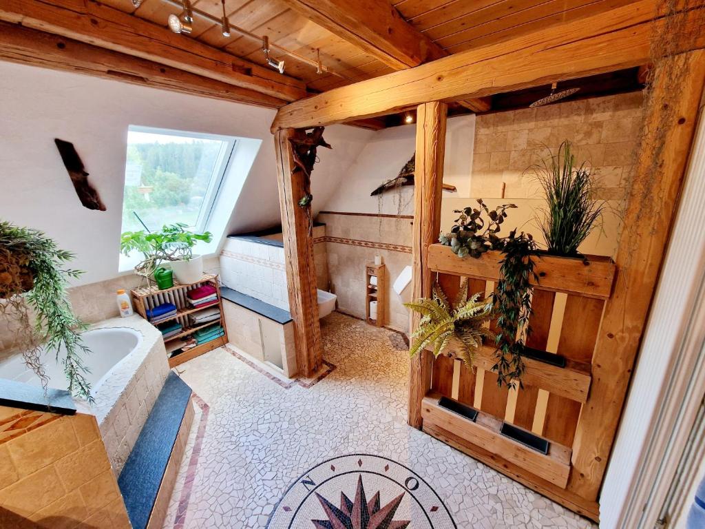 a large room with a tub and a bedroom at Wood & Stone Lodge 2 in Donaueschingen