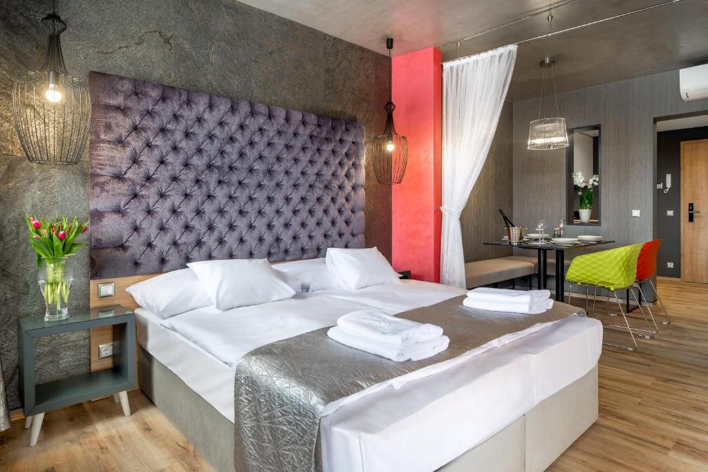 a bedroom with a large bed and a dining room at Onyx Luxury in Sárvár