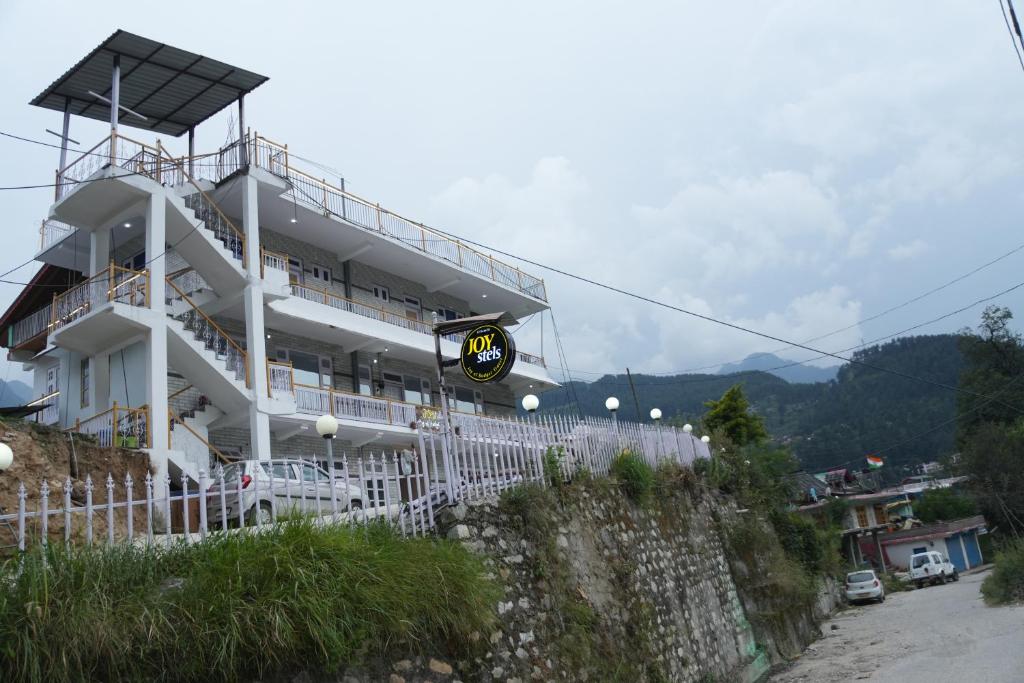 un edificio blanco en la cima de una colina en JOYstels Kasol en Kasol