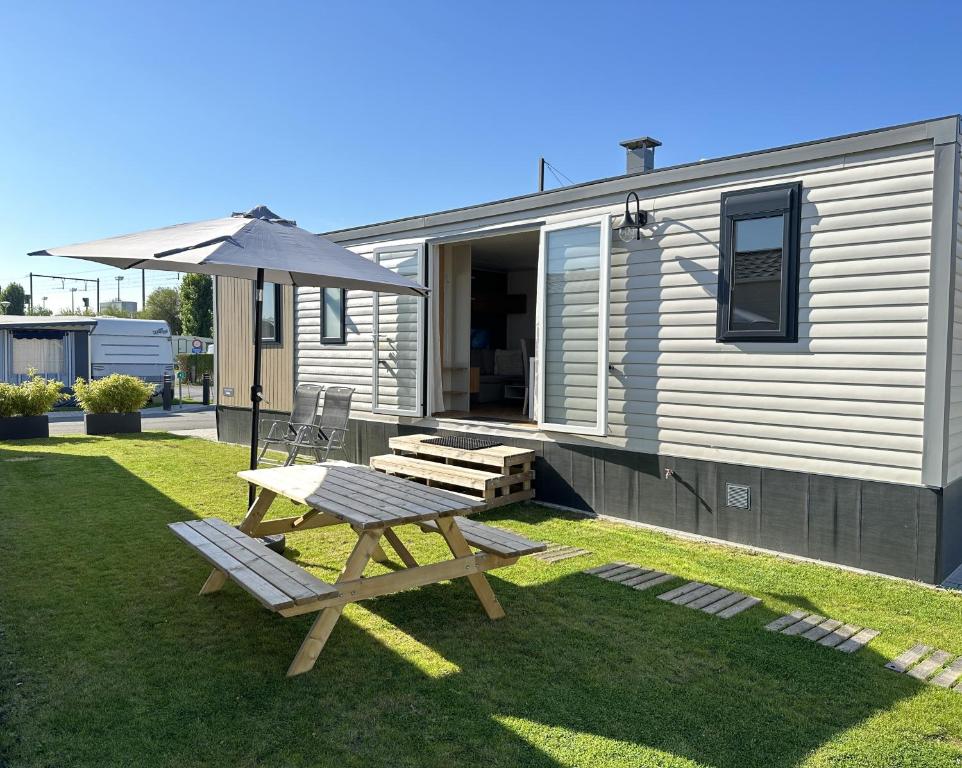 a picnic table and an umbrella in front of a house at Luxury Seaside Cottage 28 in Knokke-Heist