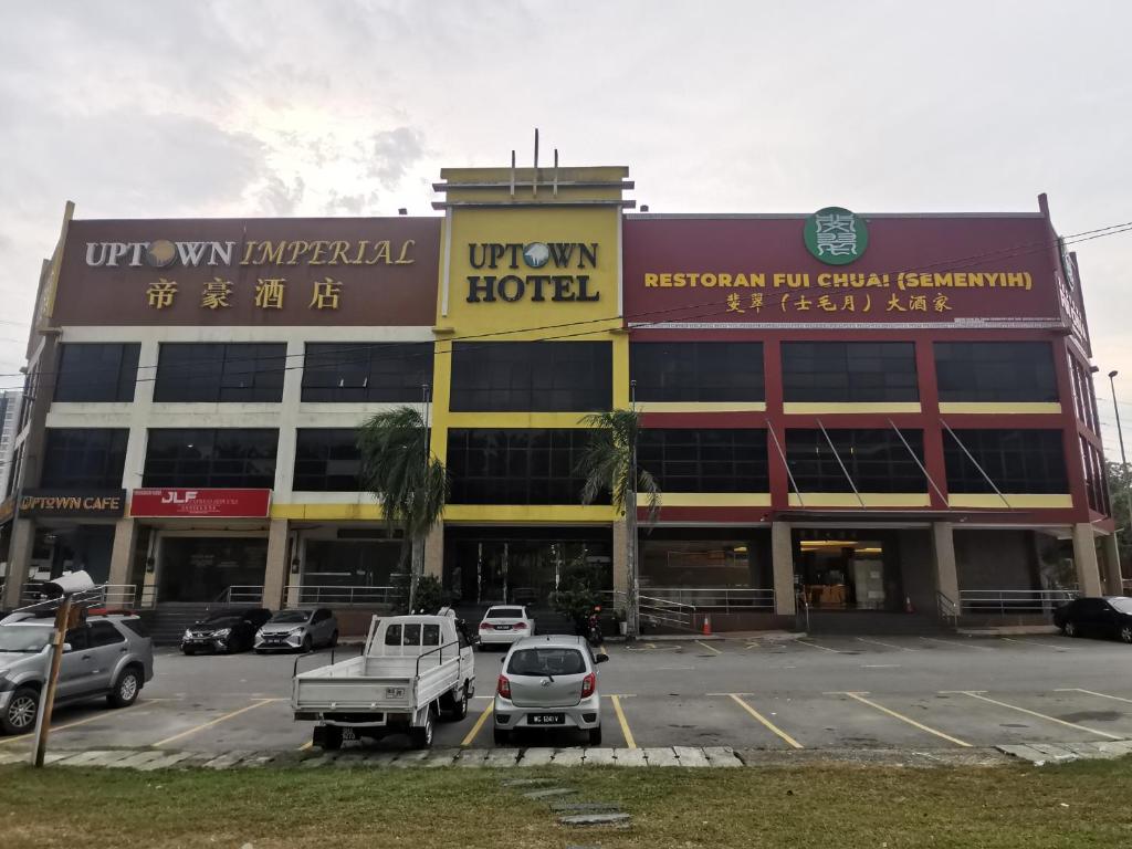 a large building with cars parked in a parking lot at Uptown Imperial in Kajang