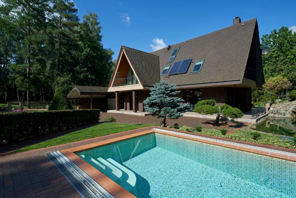 une maison avec une piscine en face d'une maison dans l'établissement Luxury villas Kaunas, à Šlienava