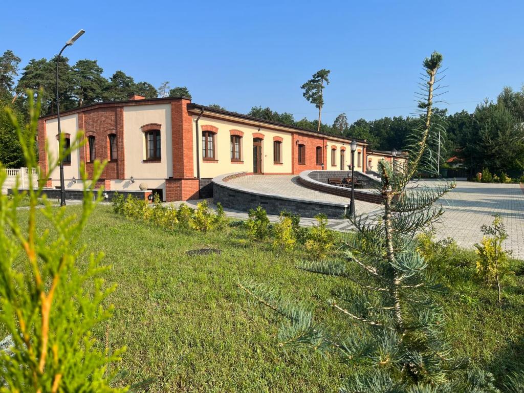 a building with a grassy yard in front of a building at Spalskie Pokoje Gościnne in Spała