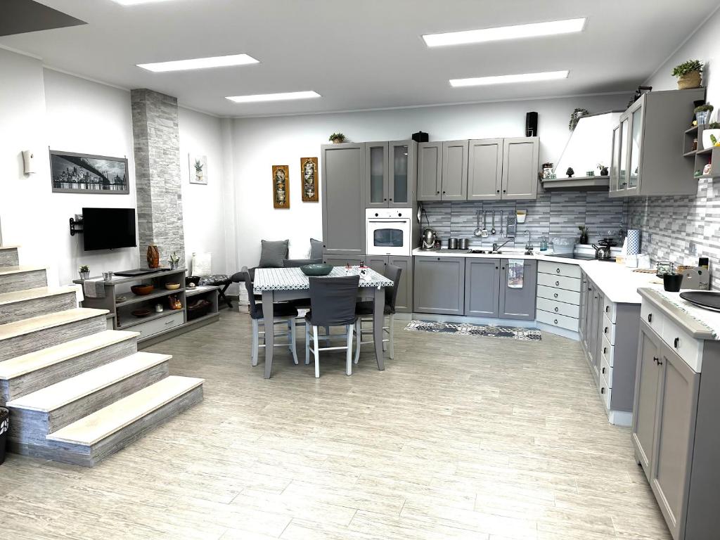 a kitchen with a table and chairs in a kitchen at Le Mandorle Apartment in Belpasso